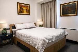 a hotel room with a bed and two lamps at The Square Hotel in Cluj-Napoca