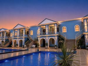 a large blue mansion with a swimming pool at Red Tullip Md Valley Resort & Spa - Luxury Resort With Swimming Pool, Udaipur in Udaipur