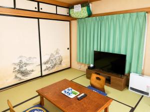a living room with a table and a television at Yamanaka Lake Ryozan in Yamanakako +39 photos