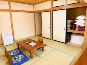 a small room with a table and chairs and towels at Yamanaka Lake Ryozan in Yamanakako