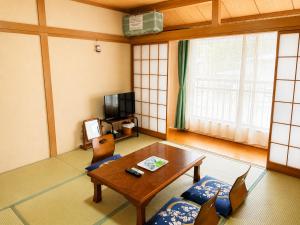 a living room with a wooden table and chairs at Yamanaka Lake Ryozan in Yamanakako