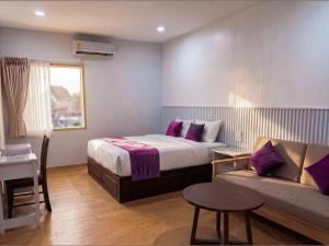a hotel room with a bed and a couch at Excel Hotel Bangkok former Sri Krungthep Hotel in Bangkok