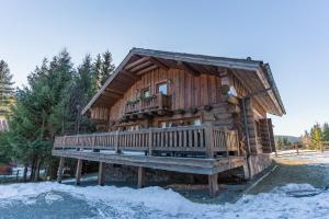 a log cabin with a deck in the snow at Chalet Vancouver in Donovaly