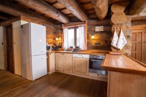 a kitchen with a white refrigerator and wooden walls at Chalet Vancouver in Donovaly