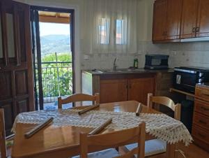 a kitchen with a table with chairs and a sink at villa vitta - bellissimo villagio in Kastrákion