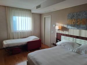 ein Hotelzimmer mit zwei Betten und einem Fenster in der Unterkunft Breaking Business Hotel in Mosciano SantʼAngelo + 52 Fotos