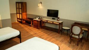 a room with a desk and a tv and a bed at Evoke Rambagh Resort Ayodhya in Ayodhya