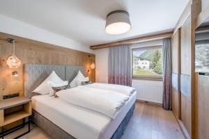 ein Schlafzimmer mit einem großen Bett und einem Fenster in der Unterkunft Hotel Rössle Superior in Galtür + 70 Fotos