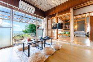 a living room with a table and a view of the ocean at Azure Kawatana in Mitsugoe