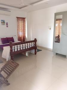 a room with a bed and a bench in it at Sushils Bed and Breakfast in Port Blair