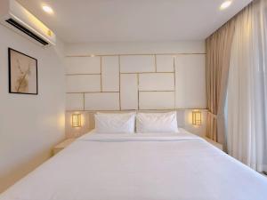 a bedroom with a large white bed with two pillows at Tatami Hotel Phuket in Ban Ket Ho