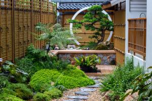 a garden with a fence and a walkway at Tatami Hotel Phuket in Ban Ket Ho +16 photos