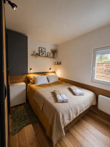 a bedroom with a large bed with two towels on it at Panorama House in Bartolovci