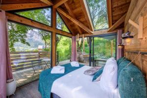 a bedroom in a tree house with a large window at Les chalets d'Éléna in Saint-Jean-Saint-Nicolas