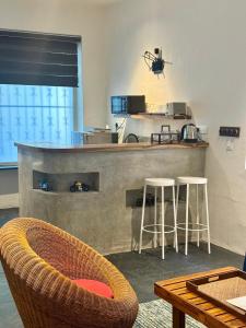 a kitchen with two bar stools and a counter at Le Jardin Suffren LOFT in Jāmb
