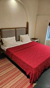 a bedroom with a large red bed with a red blanket at Le Jardin Suffren LOFT in Jāmb