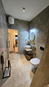 a bathroom with two sinks and two toilets at Le Jardin Suffren LOFT in Jāmb