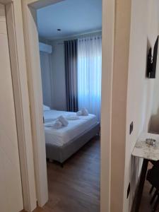a bedroom with a bed and a room with a window at Vila Familjare Vlore in Vlorë