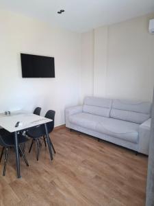 a living room with a white couch and a table at Vila Familjare Vlore in Vlorë