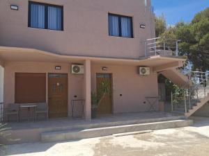 a house with doors and a table in front of it at Vila Familjare Vlore in Vlorë