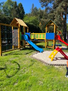 a playground with a slide and play equipment at Baracuda in Dębki +25 photos