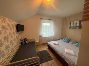 a small bedroom with a bed and a tv at Penzion V Hájku in Vřesina +46 photos