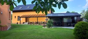 a house with a pavilion with tables and chairs at Penzion V Hájku in Vřesina