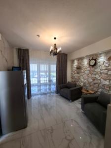 a living room with a couch and a stone wall at Апартаменты in Hanioti