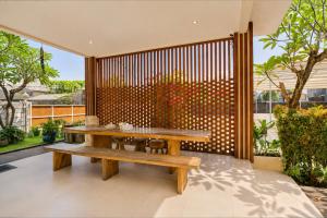a wooden table and bench on a patio at Townhouse Oak The Vinhill Studio in Bangli