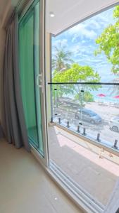a window with a view of a beach at The Oceanview Grand at Hulumale and Male in Hulhumale