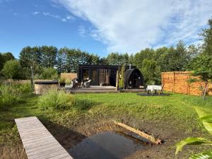 a house in the middle of a yard with a pond at Het Kleine Genoegen in Heelweg