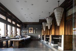 a restaurant with a bar with chairs and chandeliers at The Strathallan Rochester Hotel & Spa, Tapestry by Hilton in Rochester