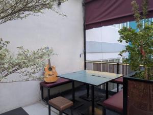 a guitar sitting on a table on a balcony at Tzone's Hostel - Quiet Place in Ho Chi Minh City