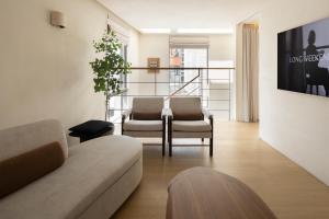 a living room with two chairs and a couch at Long Weekend Haus in Seoul