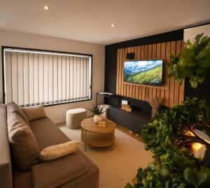 a living room with a couch and a tv at Panorama House in Bartolovci