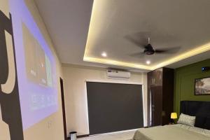 a room with a ceiling fan and a projection screen at Spacious Apartment by Urban Residence in Multan +3 photos