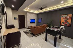 a living room with a couch and a foosball table at Spacious Apartment by Urban Residence in Multan