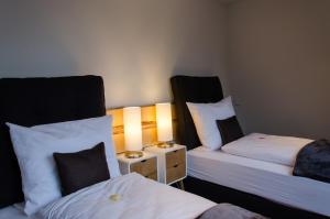 Zimmer mit 2 Betten und einem Nachttisch mit 2 Lampen in der Unterkunft Bingers kleine Scheune in Willich