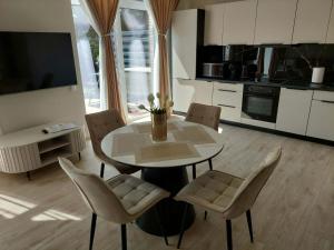 a living room with a table and chairs and a kitchen at Sweet villa Palanga in Palanga