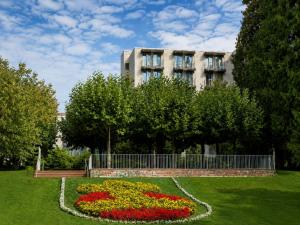 a building with a garden with flowers in a park at Sunday Hotel Bad Soden in Bad Soden am Taunus +51 photos