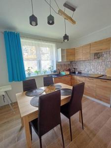 a kitchen with a wooden table and chairs in it at Dom JAMAR - apartamenty in Jastrzębia Góra