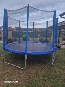 a blue trampoline with a canopy on the grass at Apartmani Lux Nina in Vrdnik