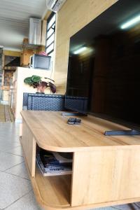 a large flat screen tv sitting on top of a desk at Bungalow Le Cocotier in Sainte-Rose
