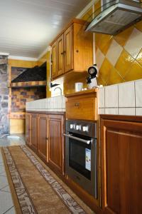 a kitchen with wooden cabinets and a stove top oven at Bungalow Le Cocotier in Sainte-Rose