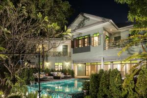 a villa with a swimming pool at night at The Raweekanlaya Bangkok in Bangkok