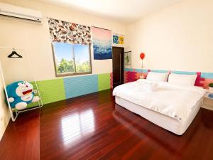 a bedroom with a white bed and colorful walls at 台東醇旅旅宿-民宿編號1417 in Lijia