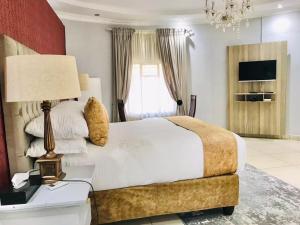 a bedroom with a bed with a lamp and a television at Radiant Resort in Manzini