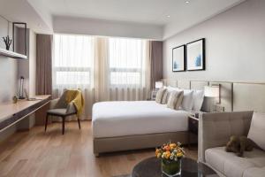 a hotel room with a large bed and a couch at Shama Daqing Heilongjiang in Daqing +89 photos
