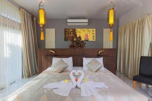 two swans made out of towels on a bed at Villa Oxavia in Rawai Beach +86 photos
