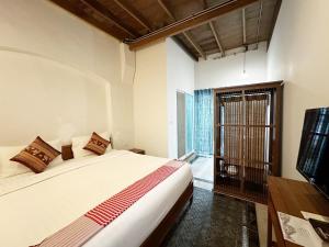 a bedroom with a bed and a tv and a window at Neighbor Phuthon in Bangkok